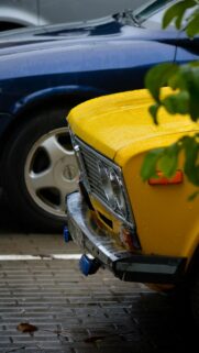 Vintage Yellow Soviet Car on Rainy Street Mobile Wallpaper