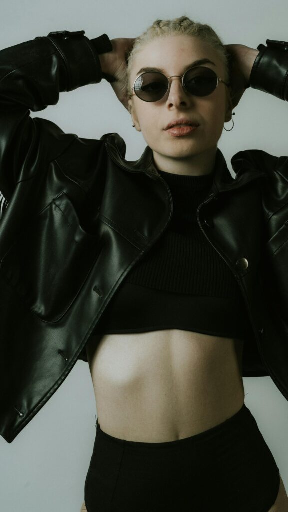 Edgy Blonde Woman in Leather Jacket and Sunglasses Cool Aesthetic Wallpaper