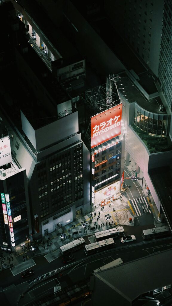 Aerial View of Vibrant Tokyo City Street at Night Phone Wallpaper