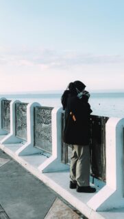 Woman Photographer at Seaside Pier Minimalist Aesthetic Wallpaper