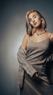 Chic Woman in Plaid Blazer and Silk Slip Dress Portrait Wallpaper