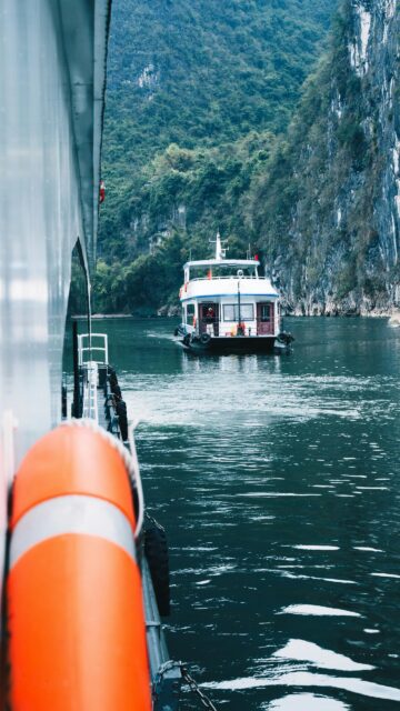 Breathtaking Scenic Boat Cruise Through Limestone Mountains Mobile Wallpaper