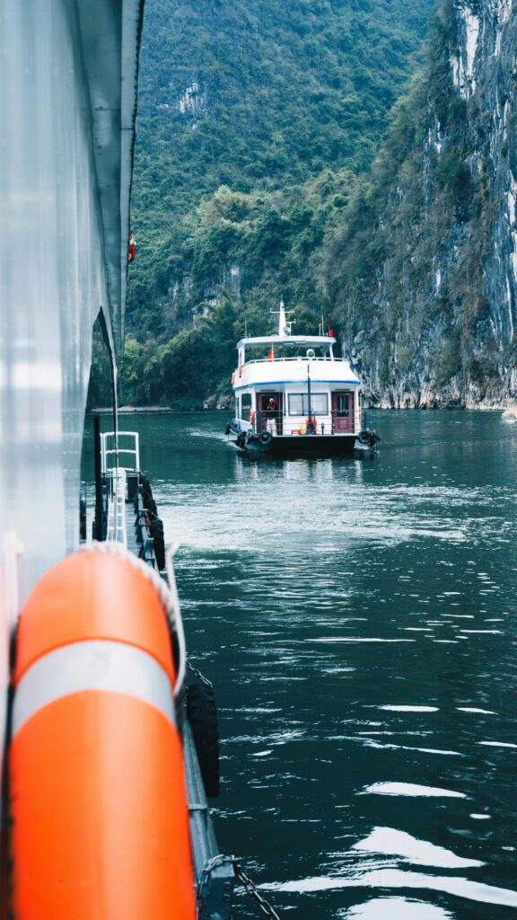 Breathtaking Scenic Boat Cruise Through Limestone Mountains Mobile Wallpaper