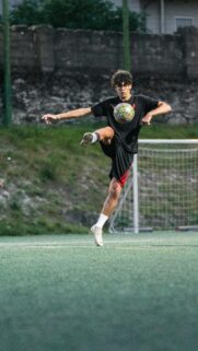 Soccer Player Mid-Air Kick Action Shot Mobile Wallpaper