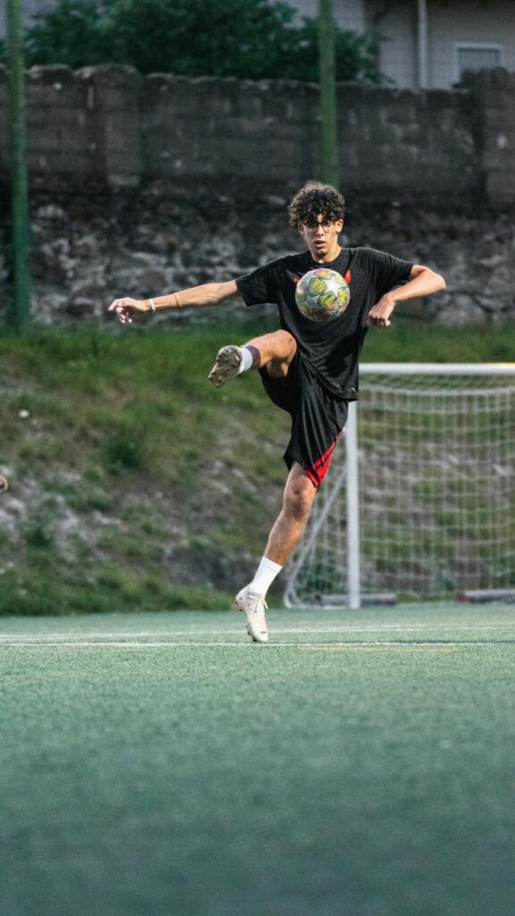 Soccer Player Mid-Air Kick Action Shot Mobile Wallpaper
