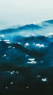 Stunning Aerial View of Misty Blue Mountains and Scattered Clouds Wallpaper
