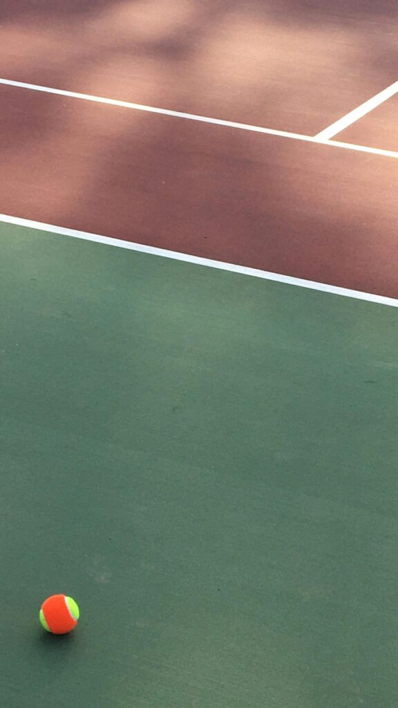 Minimalist Tennis Court View with Bright Orange Ball Mobile Wallpaper