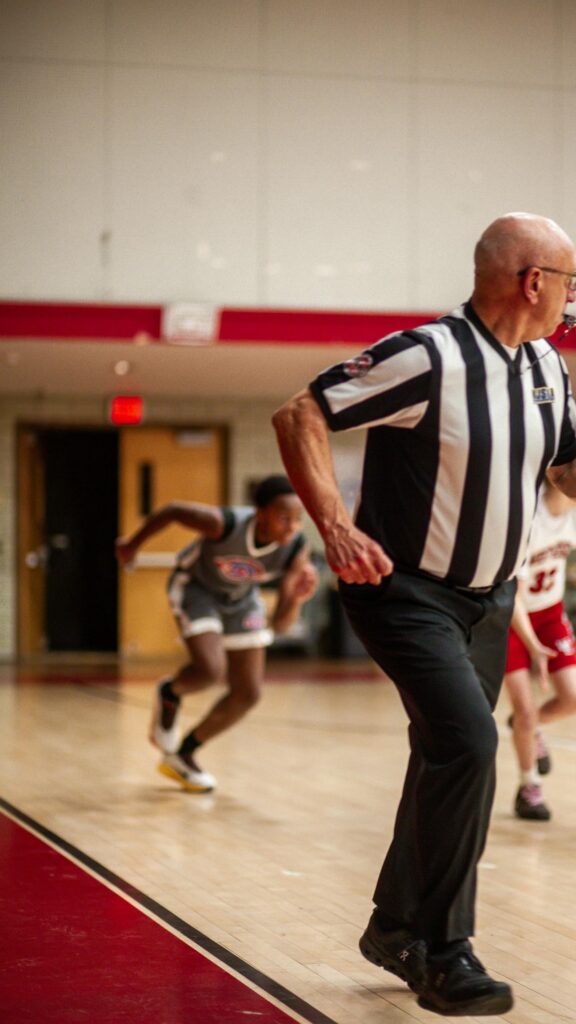 Basketball Referee and Player Action Shot Mobile Wallpaper