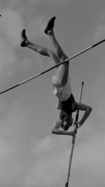 Vintage Pole Vault Athlete Mid-Air Action Shot Mobile Wallpaper