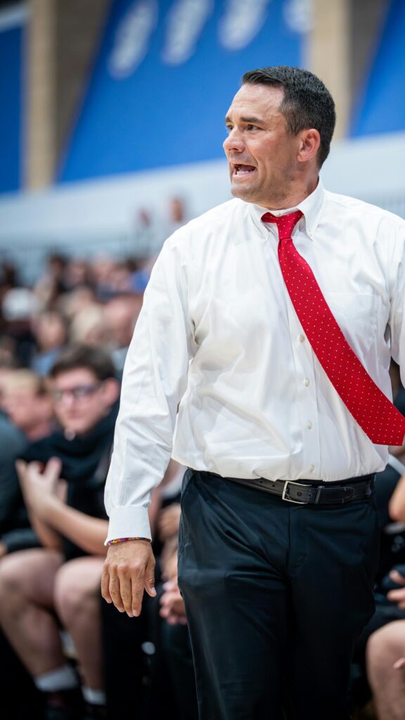 Focused Basketball Coach in White Shirt and Red Tie Mobile Wallpaper