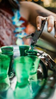 Vibrant Blue Cocktail Shots Pouring at a Party Mobile Wallpaper