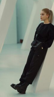 Stunning Blonde Fashion Model Leaning Against Minimalist Pillar Wallpaper