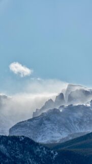 Snow-Covered Mountain Peaks with Blowing Winter Mist Wallpaper