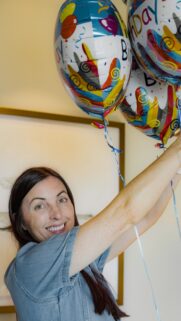 Smiling Woman Holding Colorful Birthday Balloons Mobile Wallpaper