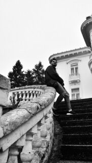 Stylish Man Sitting on Historic Stone Balustrade Monochrome Wallpaper
