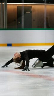 Graceful Ice Skater Performing Arching Move Phone Wallpaper