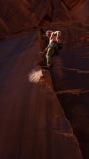 Rock Climber Ascending Red Sandstone Canyon Cliff Mobile Wallpaper