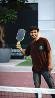 Young Man Holding Pickleball Paddle on Court Mobile Wallpaper