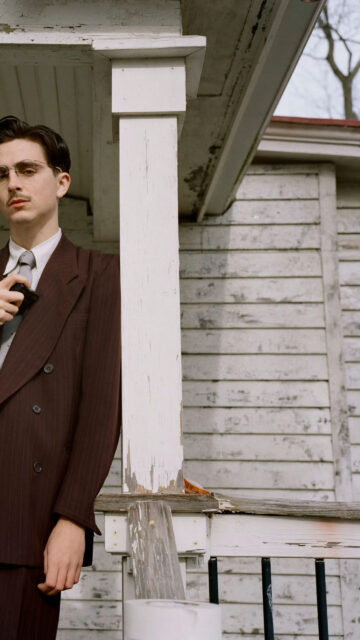 Vintage Style Man Leaning on Porch Post Mobile Wallpaper