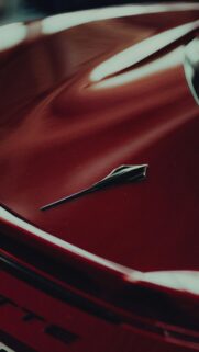 Close Up Red Sports Car Hood Ornament Luxury Aesthetic Wallpaper