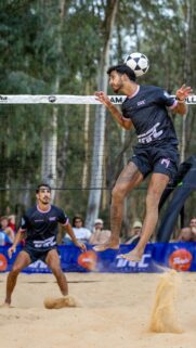 Dynamic Footvolley Player Heading Ball on Sand Beach Wallpaper