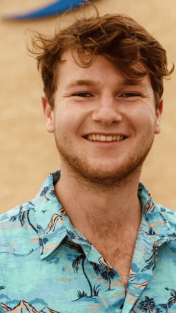 Smiling Young Man in Tropical Shirt Mobile Wallpaper