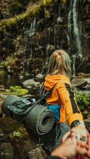 Woman Leading Follow Me to Waterfall Adventure Phone Wallpaper