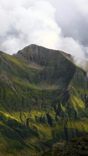 Majestic Green Mountain Peak Under Cloudy Sky Mobile Wallpaper