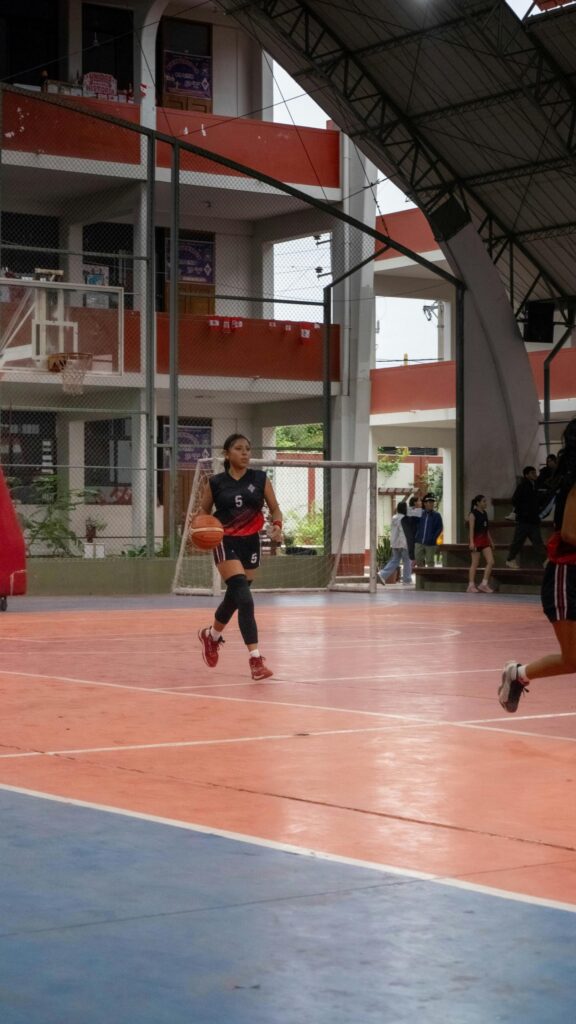 Athletic Basketball Player Dribbling on Indoor Court Wallpaper