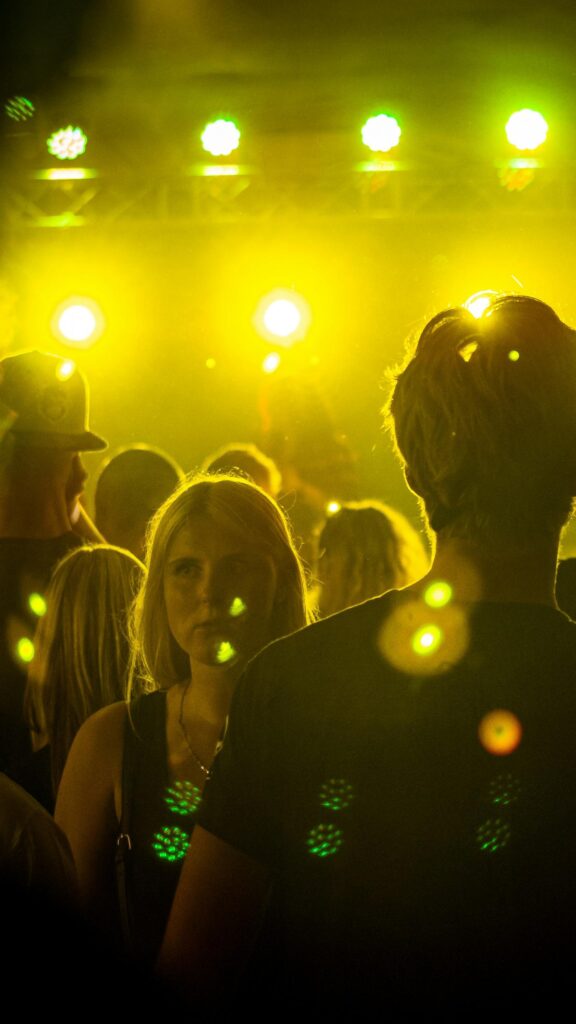 Vibrant Nightclub Crowd and Golden Stage Lights Mobile Wallpaper