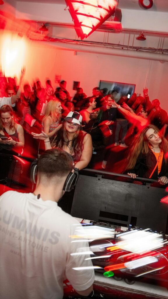 Vibrant Nightclub Party Crowd and DJ Performance Mobile Wallpaper