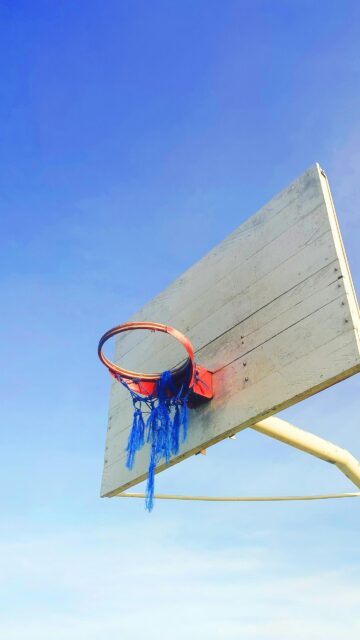 Rustic Basketball Hoop with Blue Net Against Clear Sky Wallpaper