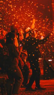 People Dancing at Night Concert with Glowing Confetti Effects Wallpaper