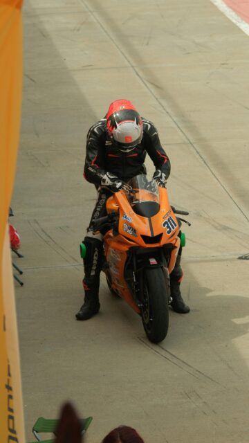 Professional Motorcycle Racer on Orange Superbike Wallpaper