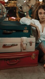 Vintage Aesthetic Girl with Stacked Retro Suitcases Mobile Wallpaper