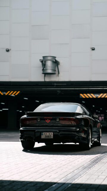 Sleek Black Pontiac Firebird Sports Car Urban Parking Wallpaper
