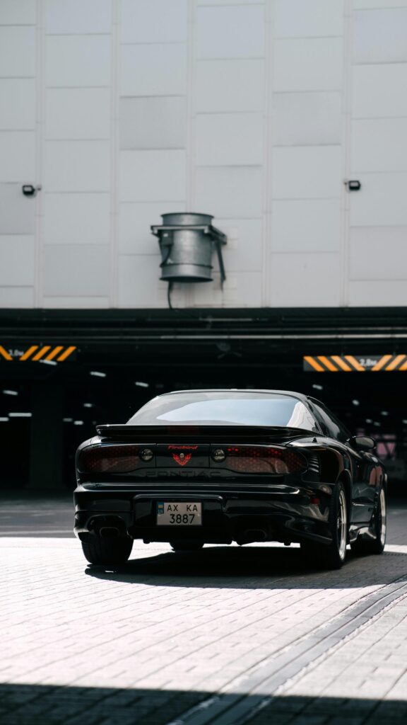 Sleek Black Pontiac Firebird Sports Car Urban Parking Wallpaper