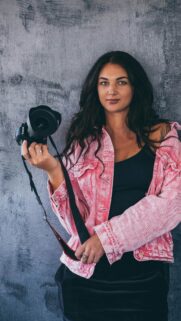 Stunning Portrait of a Woman with Canon Camera and Pink Jacket Wallpaper