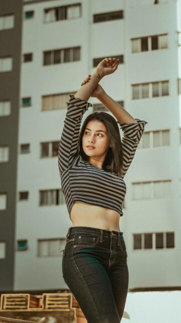 Beautiful Young Woman Posing in Striped Crop Top Mobile Wallpaper