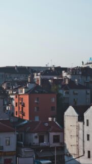 Sunlit Urban Rooftops and Architectural Cityscape Mobile Wallpaper
