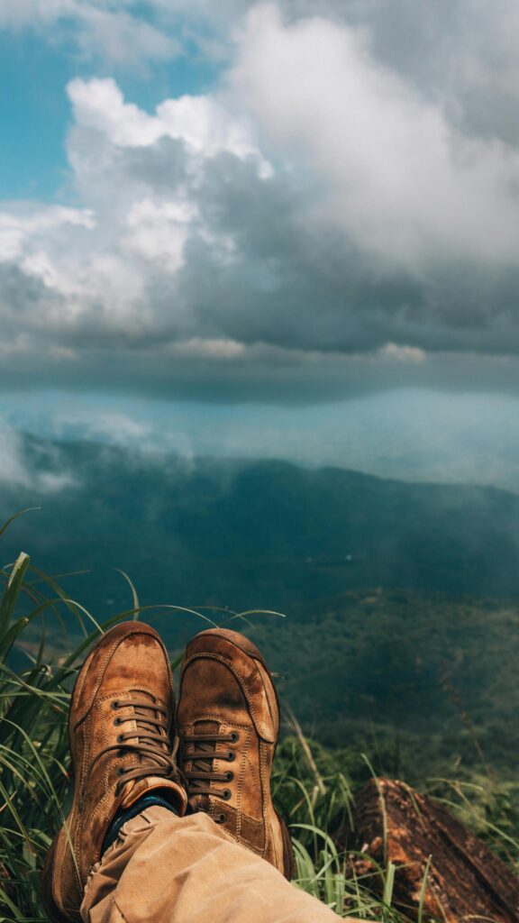 Hiking Boots Overlooking Epic Mountain Clouds Mobile Wallpaper