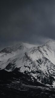 Dramatic Snowy Mountain Peak in Dark Winter Clouds Phone Wallpaper