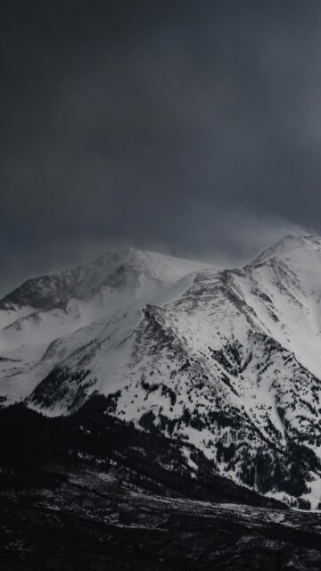 Dramatic Snowy Mountain Peak in Dark Winter Clouds Phone Wallpaper