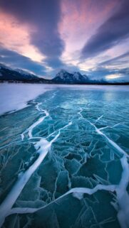 Breathtaking Frozen Lake Landscape with Cracked Ice and Majestic Mountains Wallpaper