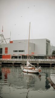 Sailboat on Calm Harbor Waters Moody Architecture Wallpaper