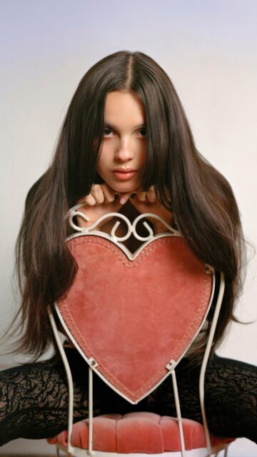Beautiful Young Woman Posing on a Pink Heart Chair Wallpaper for Mobile