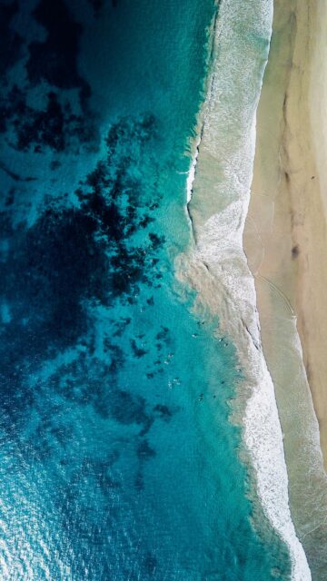 Stunning Aerial View of Tropical Ocean Beach with Surfers High Resolution Mobile Wallpaper