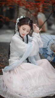 Beautiful Woman in Traditional Hanfu Dress Sitting Under Autumn Leaves Wallpaper