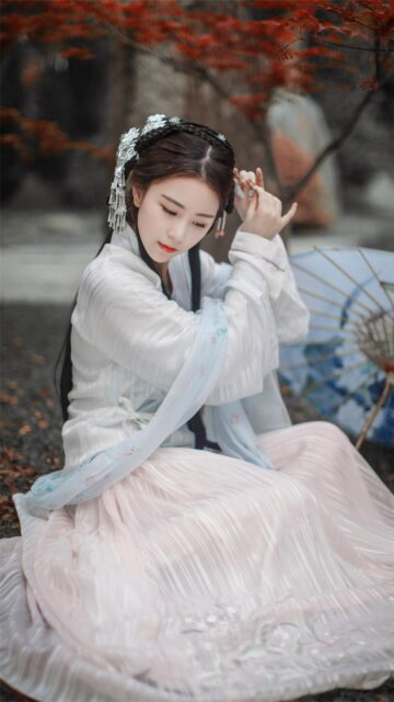Beautiful Woman in Traditional Hanfu Dress Sitting Under Autumn Leaves Wallpaper