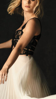 Elegant Blonde Woman in Lace and Pleated Skirt Mobile Wallpaper